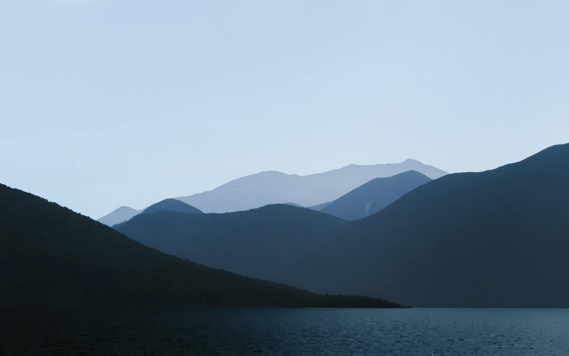 photo of mountains near body of water